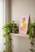 Sliced Mango Pink print displayed with houseplants