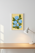 Hydrangea on Yellow print framed next to a desk lamp